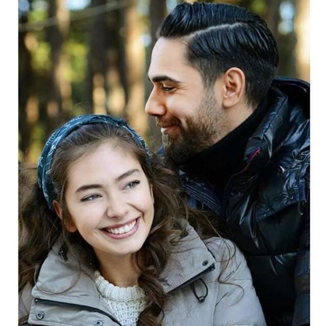 Neslihan Atagül smiling while wearing a gray jacket and blue headband  and Kadir Dogulu wearing a black jacket