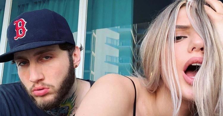 FaZe Banks looking serious with a beard while wearing a blue shirt and cap with Alissa Violet doing a wacky face and holding her hair