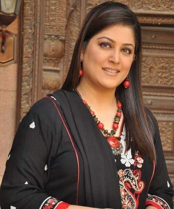 Fazila Kaiser wearing red earrings, necklace and black dress with touch of color white and red