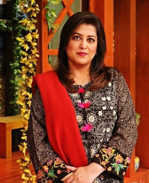 Fazila Kaiser's tight lipped smile while wearing a colorful floral dress