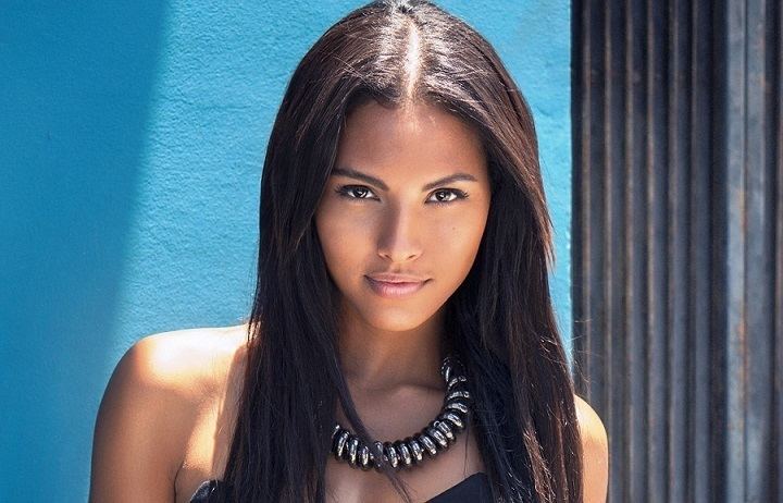 Felisha Cooper's tight lipped smile while wearing spiral necklace