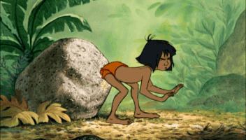 Mowgli is topless while bending his body, with short black hair, and wearing orange shorts in a scene from Mowgli: Legend of the Jungle.