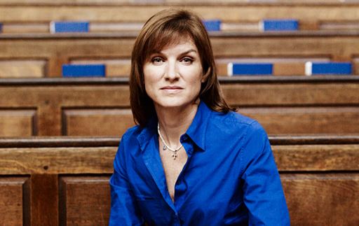 Fiona Bruce wearing a necklace and blue long sleeves.