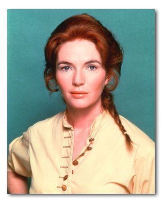 A younger Fionnula Flanagan with long reddish hair and wearing a yellow buttoned shirt.