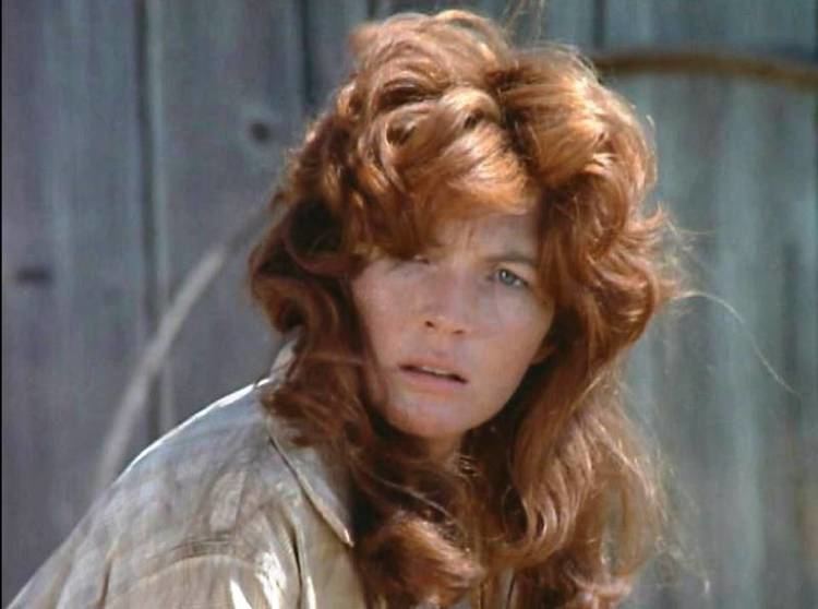 A younger Fionnula Flanagan with long reddish hair and wearing light brown clothes in a scene  from Bonanza, 1959.