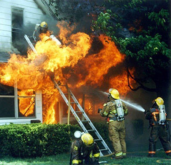Firemen extinguishing the fire of a burning house