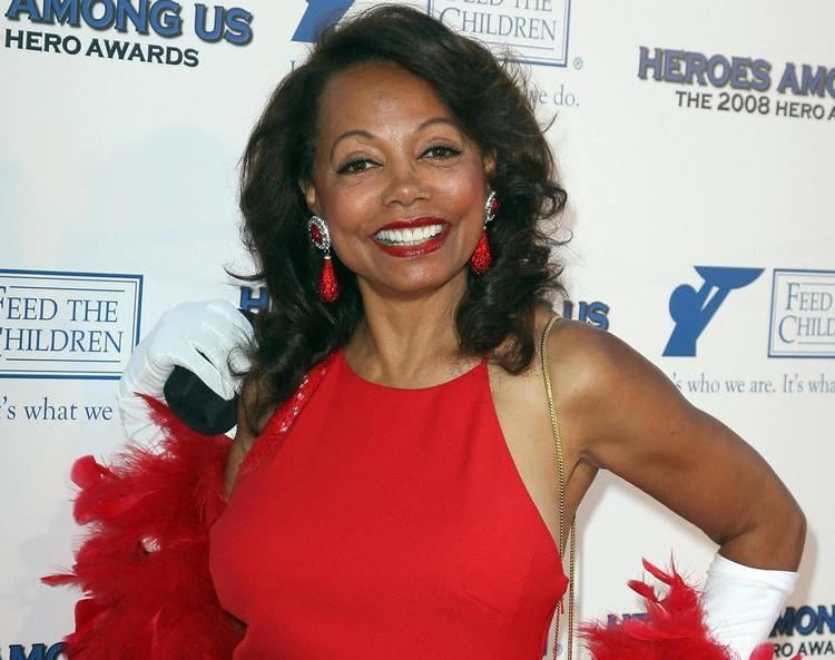 Florence LaRue in her gorgeous smile while wearing red dress and red earrings