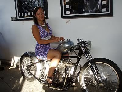 Woman riding on a motorcycle while wearing white and violet dress