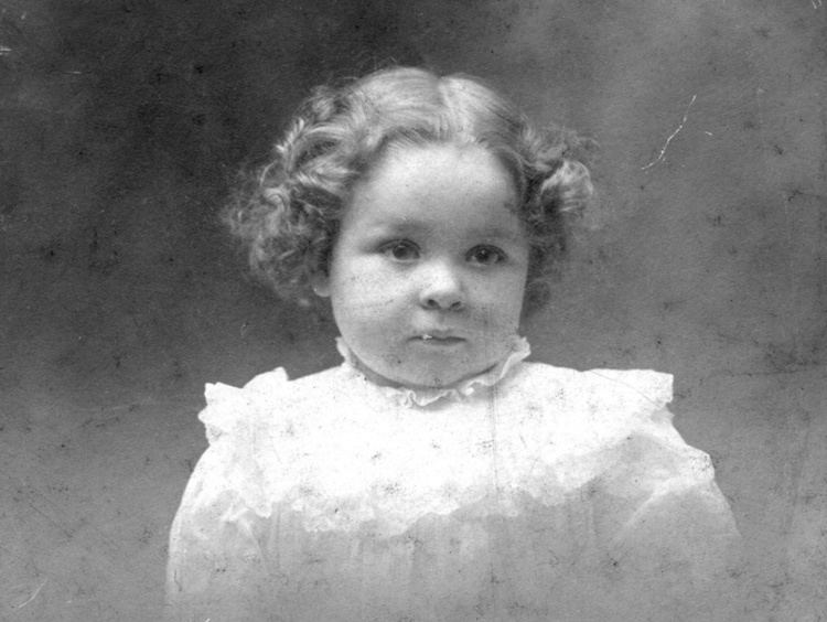 Young Frances Bavier with curly hair while wearing a dress