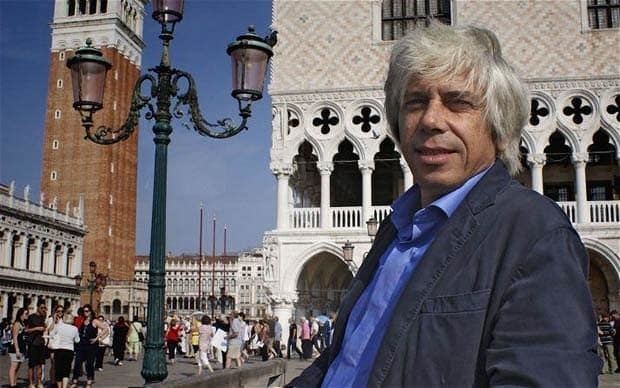 Francesco da Mosto smiling while wearing black coat and blue long sleeves