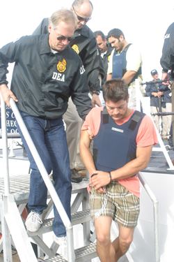 Francisco Javier Arellano Felix was captured by the Coast Guardsmen on August 16, 2006, wearing a blue vest, orange shirt, and brown checkered shorts.