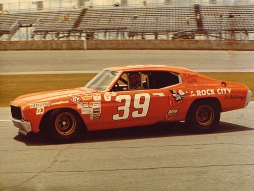 Friday Hassler driving a red racing car with a No. 39 on it and wearing a white helmet.