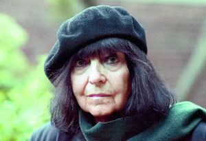 Friederike Mayröcker wearing a black shirt and hat, and a gray scarf