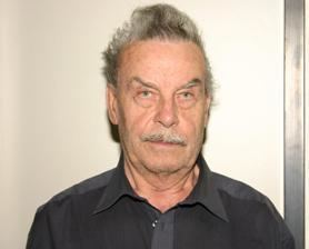 Josef Fritzl with a mustache and wearing a black shirt.
