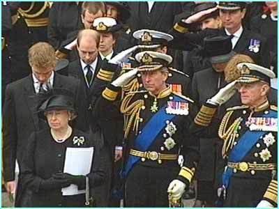 At Funeral of Queen Elizabeth The Queen Mother, At the back from left, a man is serious, standing, looking down, has brown bald hair, wearing a white polo with black necktie, under a black vest and black coat, 2nd from left, the Princess Royal Anne Elizabeth Alice Louise is serious, standing, right hand over his forehead saluting left hand down holding a Curtana, has brown, wearing black and white military uniform cap white gloves, black military coat with yellow treads, at the right a man is serious, standing, right hand over his forehead saluting has black hair, wearing black and white military uniform cap white gloves, black military coat with white polo and black necktie medals, 2nd row from left, Prince William is serious, standing, looking down, has brown hair, wearing a white polo with black necktie, under a black vest and black coat, 2nd from left Prince Edward, Earl of Wessex, standing looking down, has brown bald hair wearing a white polo with black necktie, under a black vest and black coat, 3rd from left, a man, standing, right hand over his forehead saluting left hand down holding a Curtana, has black hair, wearing black and white military uniform cap white gloves, black military coat with yellow treads, gold medals, gold belts and blue sash, 4th from left a woman is serious, standing, looking down, wearing a black hat with feathers a black coat and black skirt, at the right a man is serious, standing, looking down, has brown hair, wearing a white polo with black necktie, under a black vest and black coat, In front from left, Queen Elizabeth II Elizabeth Alexandra is serious, standing looking down on her right holding a black bag, and a white paper on her right arm, has white hair, wearing black hat with black feathers, black gloves, pearl earrings, pearl necklace, and a black dress with white brooch. In the middle,The Prince of Wales Charles III is serious, standing, right hand over his forehead saluting left hand down holding a Curtana, has white hair, wearing black and white military uniform cap white gloves, black military coat with yellow treads, gold medals, gold belts and blue sash. At the right, The Duke of Edinburgh Prince Philip, is serious, standing, right hand over his forehead saluting left hand down holding a Curtana, has bald hair, wearing black and white military uniform cap white gloves, black military coat with yellow treads, gold medals, gold belts and blue sash.