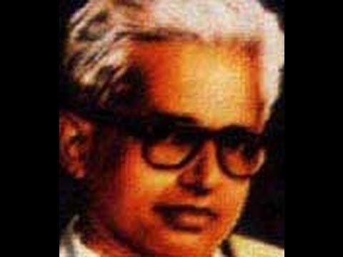 G. Sankara Kurup with white hair and a serious face while wearing eyeglasses.