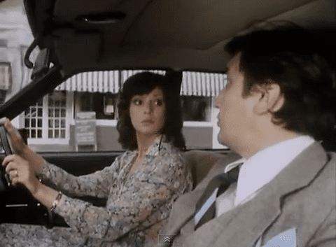 Gail Grainger looking at the man beside her while driving a car