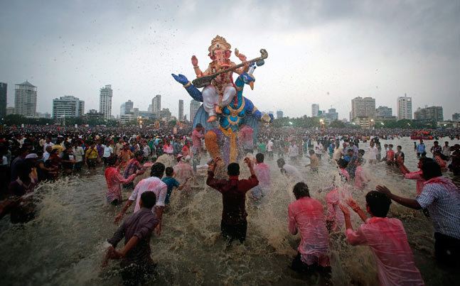 Hindu celebrants splashing water to the statue of Ganesh in the River Ganges during the festival of Ganesh Chaturthi.