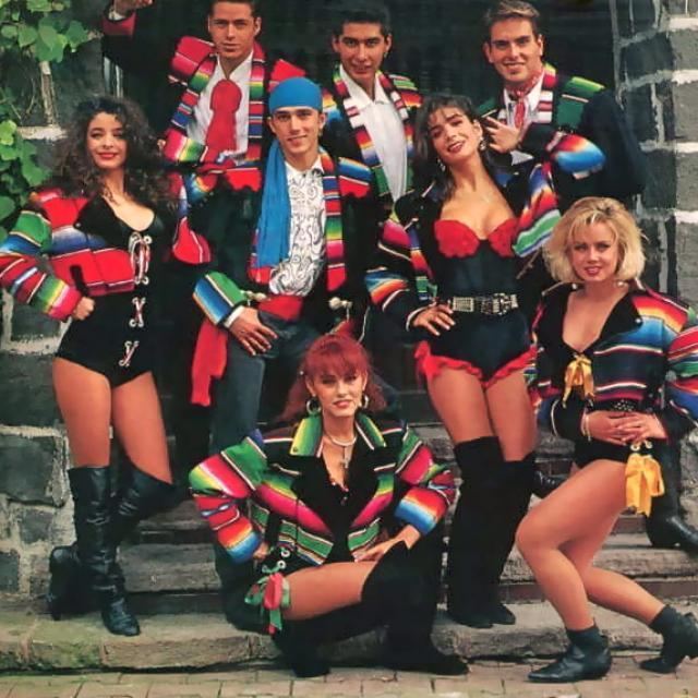 Garibaldi group smiling while the girls are wearing a colorful coat, a bodysuit, and boots while the boys are wearing a colorful coat, long sleeves, and pants