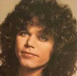 Gary Richrath with a serious face and curly hair.