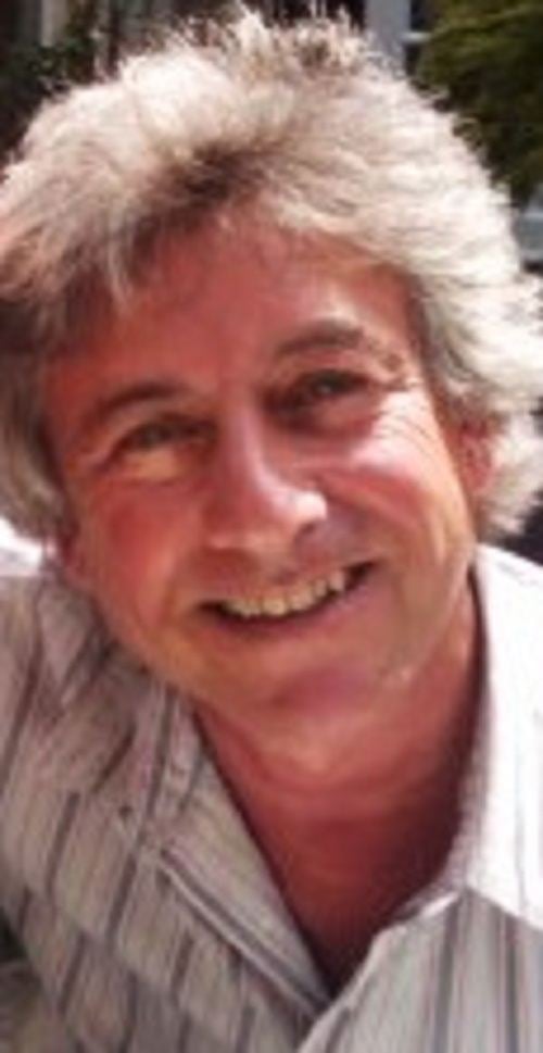 Gary Warren smiling while wearing striped long sleeves