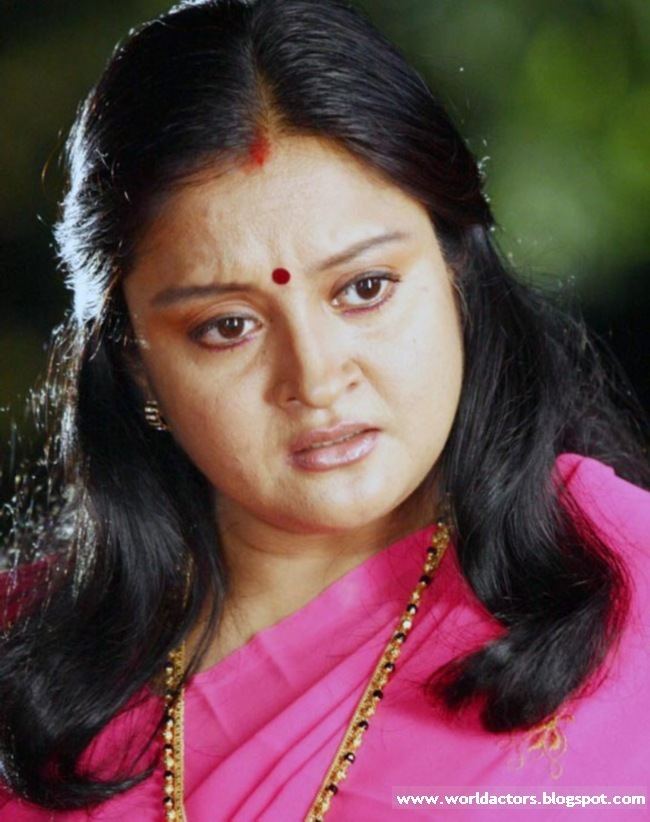 Geetha Vijayan with an angry face, wearing earrings, a necklace, and pink traditional Indian clothing for women.