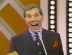 Gene Rayburn with his mouth open while wearing blue long sleeves, black necktie, and black coat