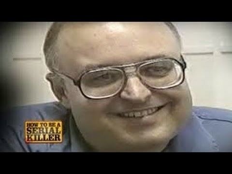 Gerard John Schaefer smiling, wearing eyeglasses and a blue polo shirt.