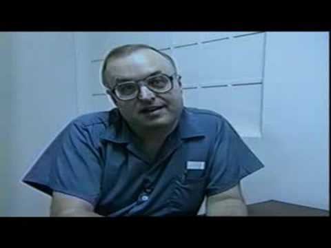 Gerard John Schaefer wearing eyeglasses and a blue polo shirt inside a cell.