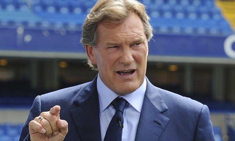 Glenn Hoddle wearing a coat while talking