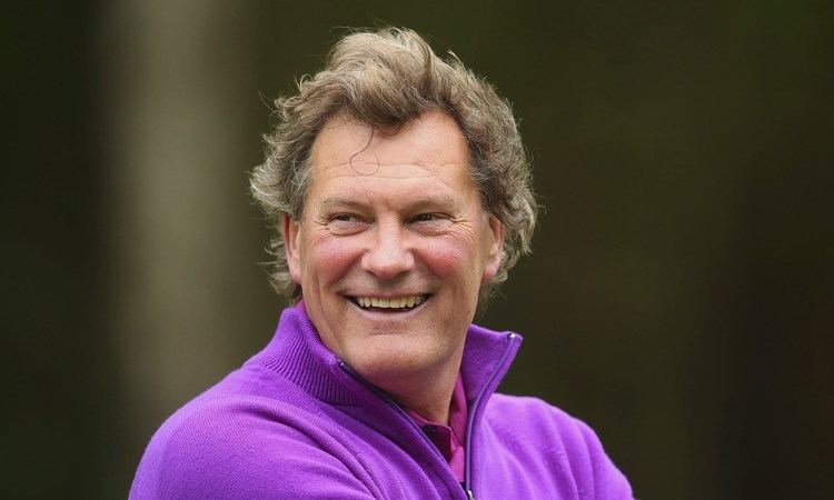 Smiling Glenn Hoddle wearing purple jacket