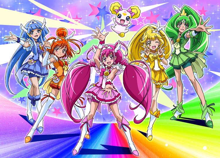 Fictional characters of Glitter Force, Reika Aoki with blue hair, Akane Hino with orange hair, Miyuki Hoshizora with pink hair, Yayoi Kise with yellow hair, Nao Midorikawa with green hair, and their pet Candy with yellow ears.