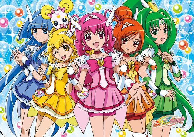 Fictional characters of Glitter Force, Reika Aoki with blue hair, Yayoi Kise with yellow hair, Miyuki Hoshizora with pink hair, Akane Hino with orange hair, Nao Midorikawa with green hair, and their pet Candy with yellow ears.