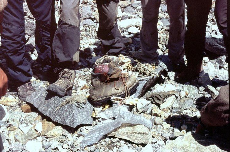 Gunther Messner’s one boot with a feet’s bone inside was found at the foot of the Diamir Glacier and local people in the background, wearing shoes and black pants