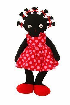 A female Golliwog rag doll wearing a spotted red dress and with ribbons in its hair.