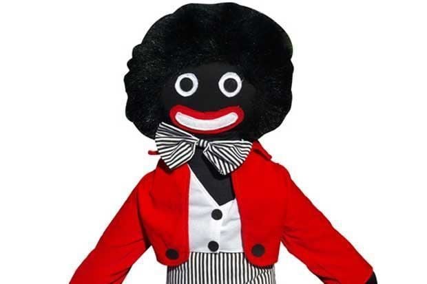 A standard male Golliwog rag doll with its trademark red suit and striped pants.