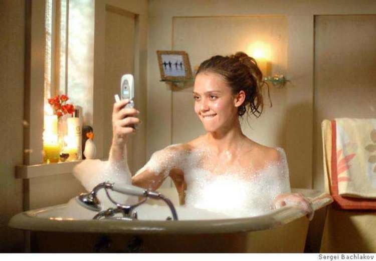 Jessica Alba biting her lips and looking at the cellphone while she is in the bathtub in a scene from the 2007 film, Good Luck Chuck