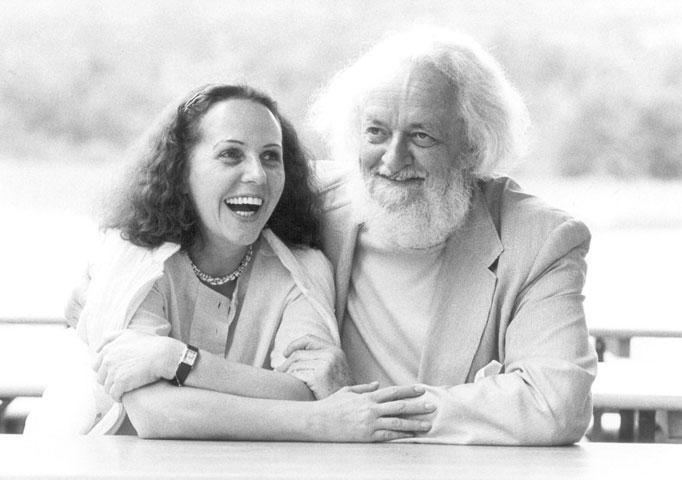 Prof. Dr. Gerda Fröhlich laughing and wearing a shawl and blouse  while beside her is Gottfried von Einem wearing a coat and shirt
