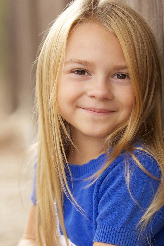 Gracie Prewitt with a tight-lipped smile while wearing a blue blouse