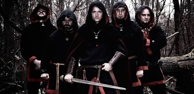 Draugir, Sigrunar, Rob Darken, Mstislav, and Bor of the band Graveland  holding a sword while in the forest and wearing black and red hooded long sleeves
