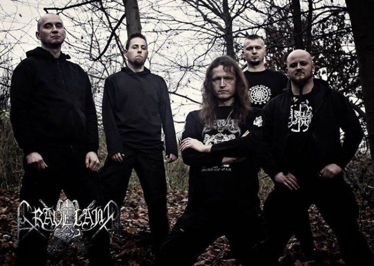 Mścisław, Zbych, Rob Darken, Miro, and Bor of Graveland band are in the forest wearing black jackets, black printed shirts, and black pants