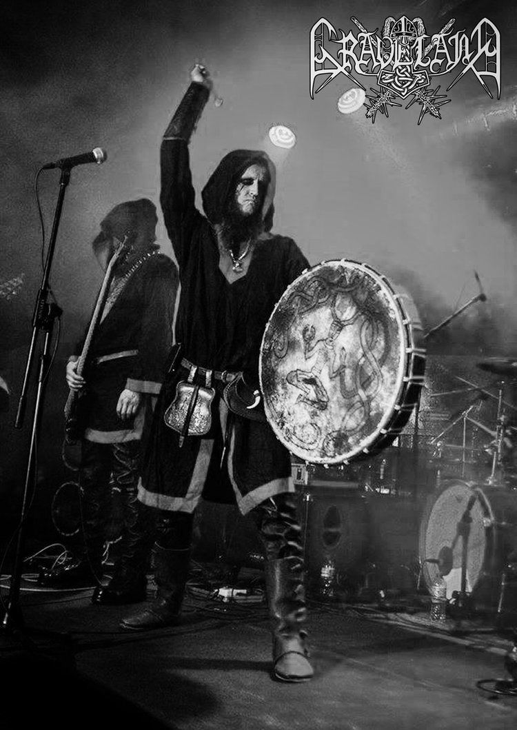 A Graveland band member holding a drum during their concert while wearing a hooded jacket, shorts, boots, and spooky make-up