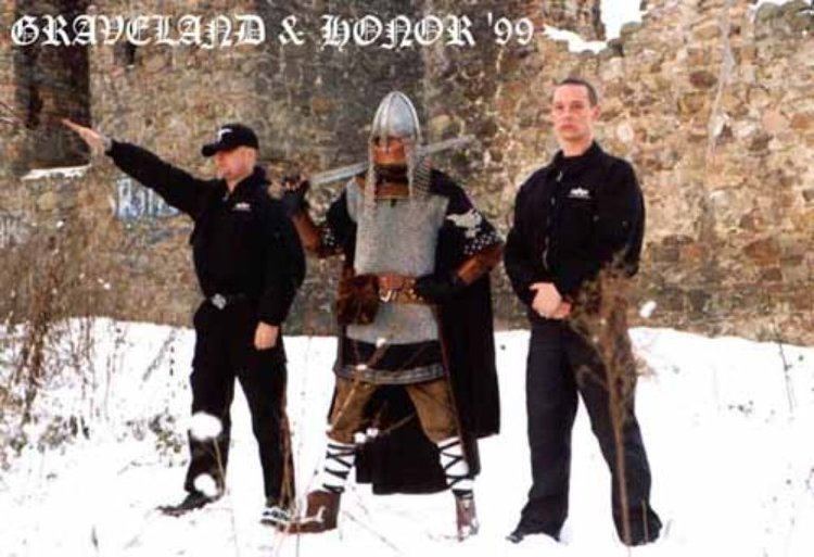 Rob Darken of Graveland band, holding a sword and wearing a helmet with the neo-Nazis group Honor at the side wearing black jackets and black pants