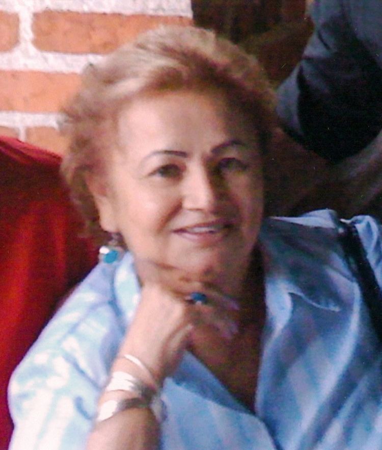 Griselda Blanco smiling while wearing a blue blouse and some pieces of jewelry