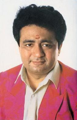 Gulshan Kumar with a serious face and wearing a pink suit and white long sleeves.