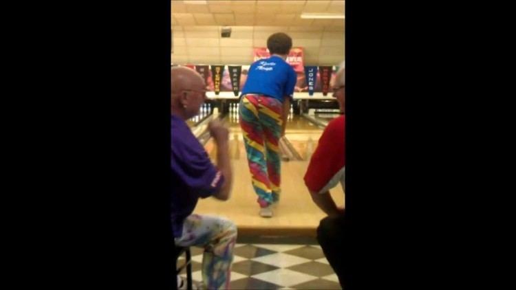 Kyle Troup wearing a blue shirt playing bowling with two men