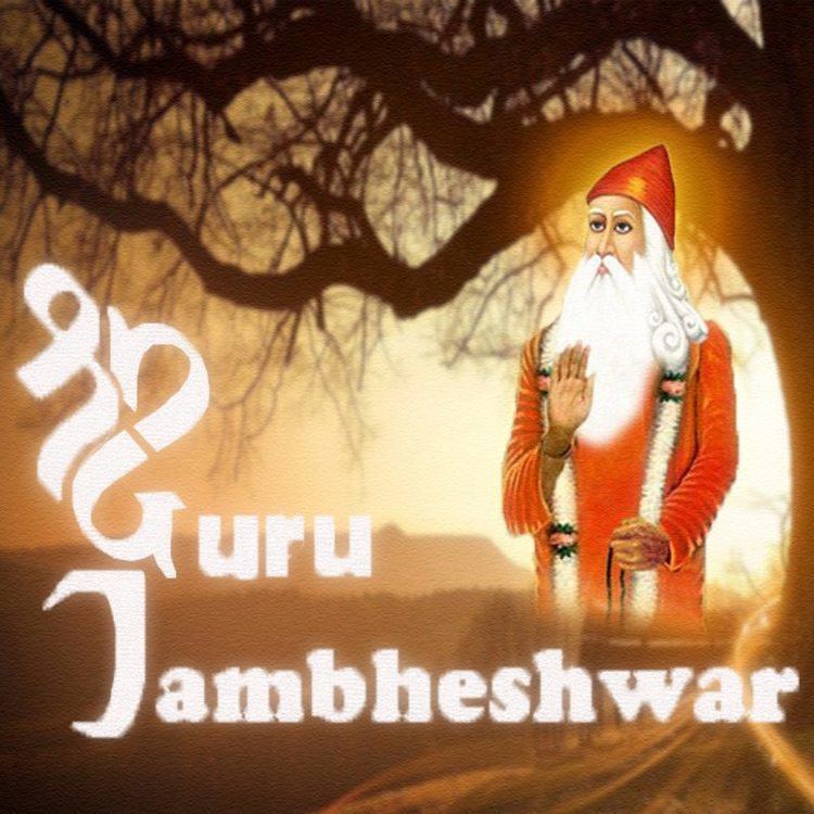 In a land in sunset with a black tree without leaves at the back right, in front, from is a word “GURU Jambheshwar” at the right Guru Jambheshwar is serious, standing, with his right hand open with his palm showing, left hand down holding a black lace, has long white hair, mustache and beard wearing a orange cap, long white garland with black and orange design and a long sleeve orange robe.