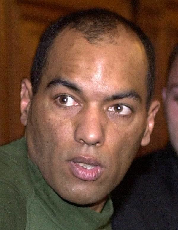 Guy Georges looking at something during his trial while wearing a green t-shirt