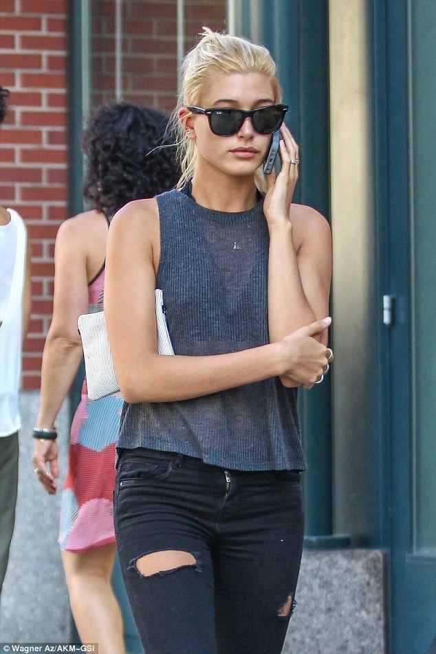 Hailey Baldwin Hailey Baldwin is glued to her phone as she wears ripped