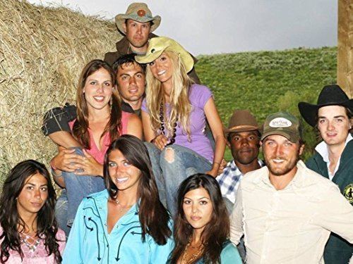 Haley Giraldo smiling with the other cast of the TV program Filthy Rich: Cattle Drive while wearing a purple blouse, jeans, and hat